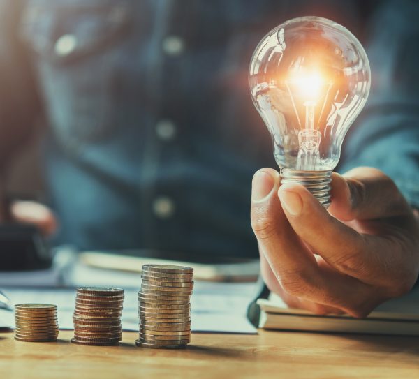 business man hand holding lightbulb with using calculator to cal business man hand holding lightbulb with using calculator to cal